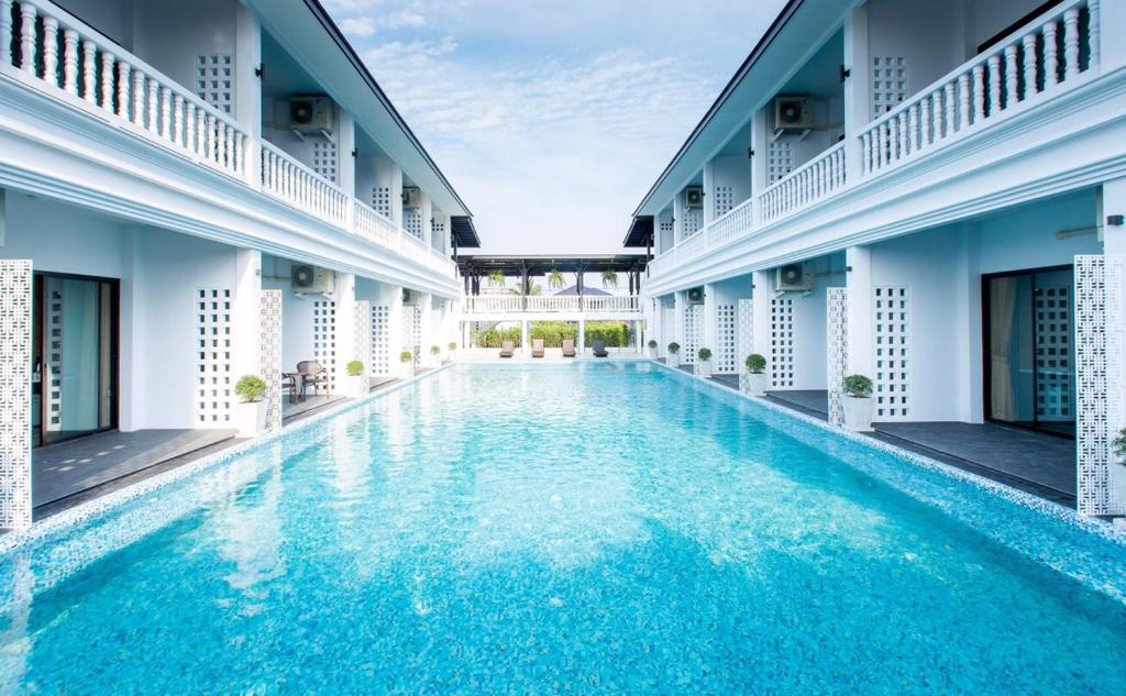 尖竹汶Chaanburi Boutique Resort的一座建筑物中央的游泳池