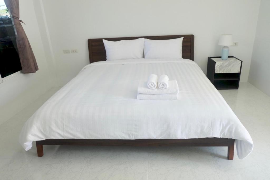 奈扬海滩Airport Pearl Residence的一间卧室配有一张床,上面有两条毛巾