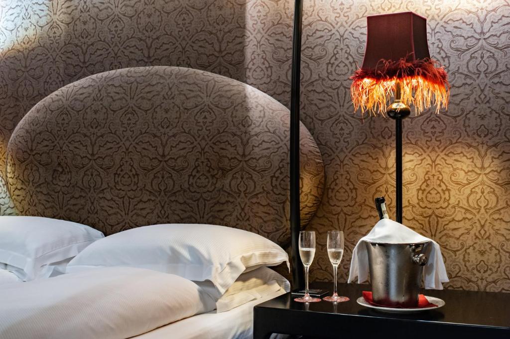 威尼斯帕拉索巴巴里戈苏卡那格兰德酒店的一间卧室配有床、灯和酒杯