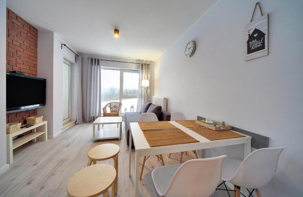 斯克拉斯卡波伦巴Apart-Invest Apartament Oslo的客厅设有餐桌和椅子