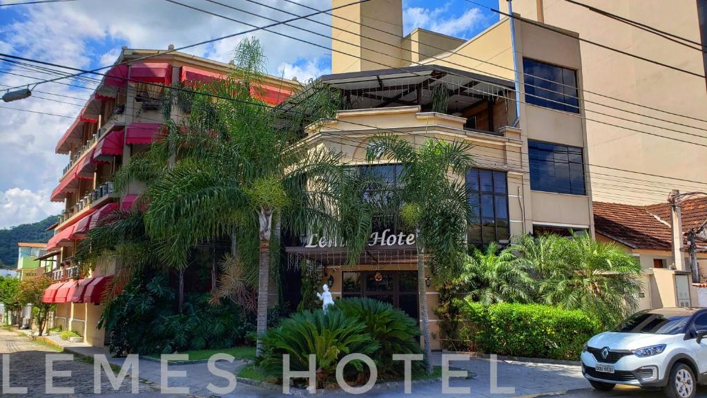 皮拉伊河畔巴拉Lemes Hotel的一座酒店大楼,前面有棕榈树