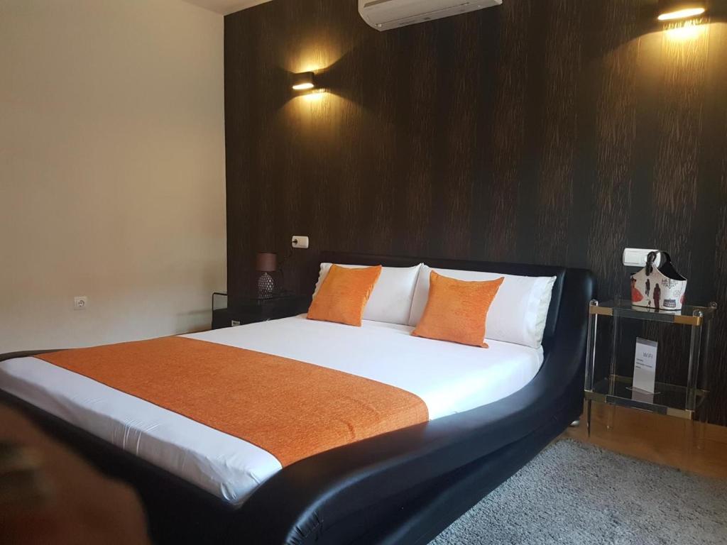 马德里APARTAMENTOS SANTA JULIANA的一间卧室配有一张带橙色枕头的大床