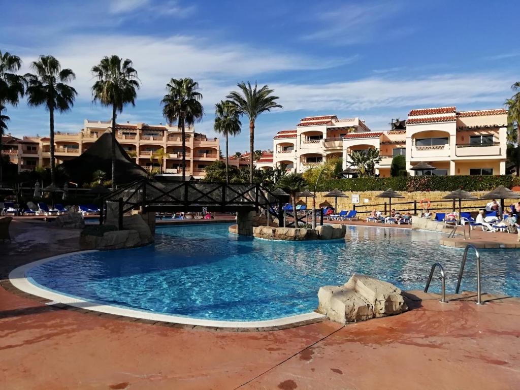 福恩吉罗拉Club La Costa World Resort的棕榈树和建筑度假村的游泳池