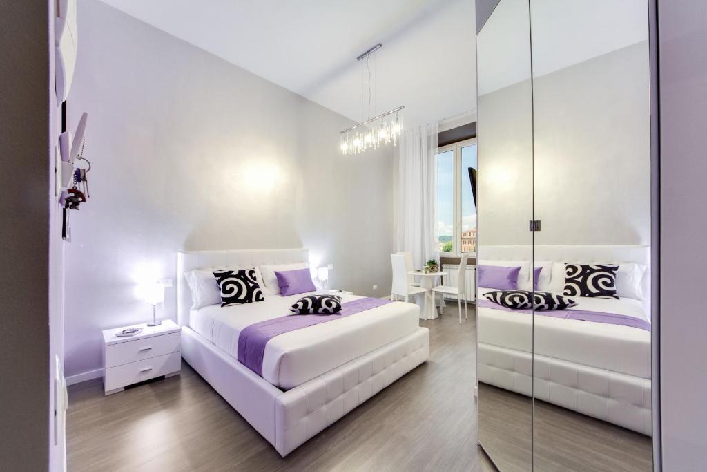 罗马斗兽场全景客房住宿加早餐酒店的一间白色卧室,配有两张床和镜子