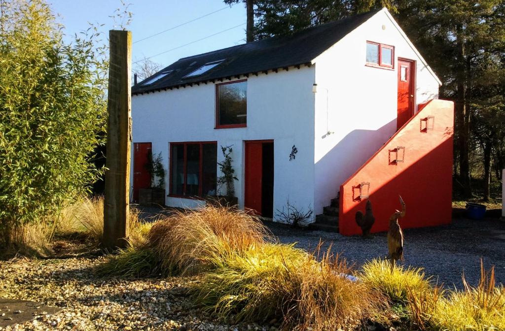 莫特The Village Studio Apartments的白色和红色的房子,有黑色的屋顶