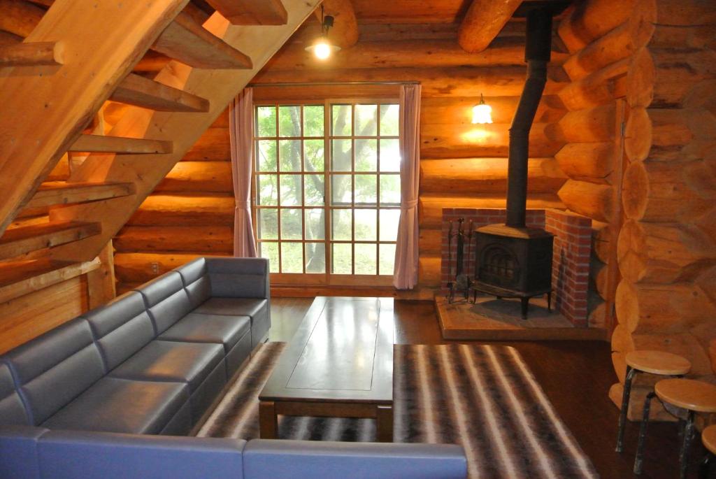 信浓White Tree Log House Madarao Tangram的带沙发和壁炉的客厅