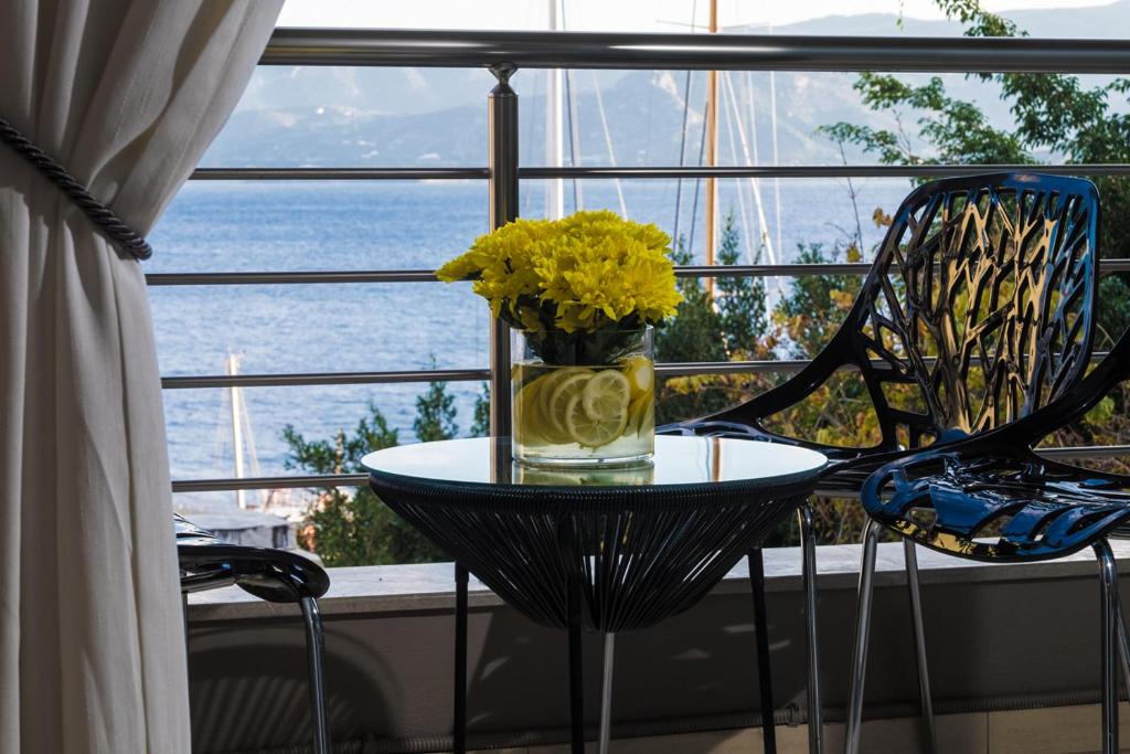 阿基欧斯尼古拉斯Holy Paraskevi Apartment的窗户前桌子上带黄色花的玻璃花瓶