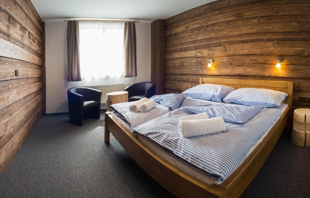 库波瓦霍特Hotel Kristian的一间卧室配有一张木墙床
