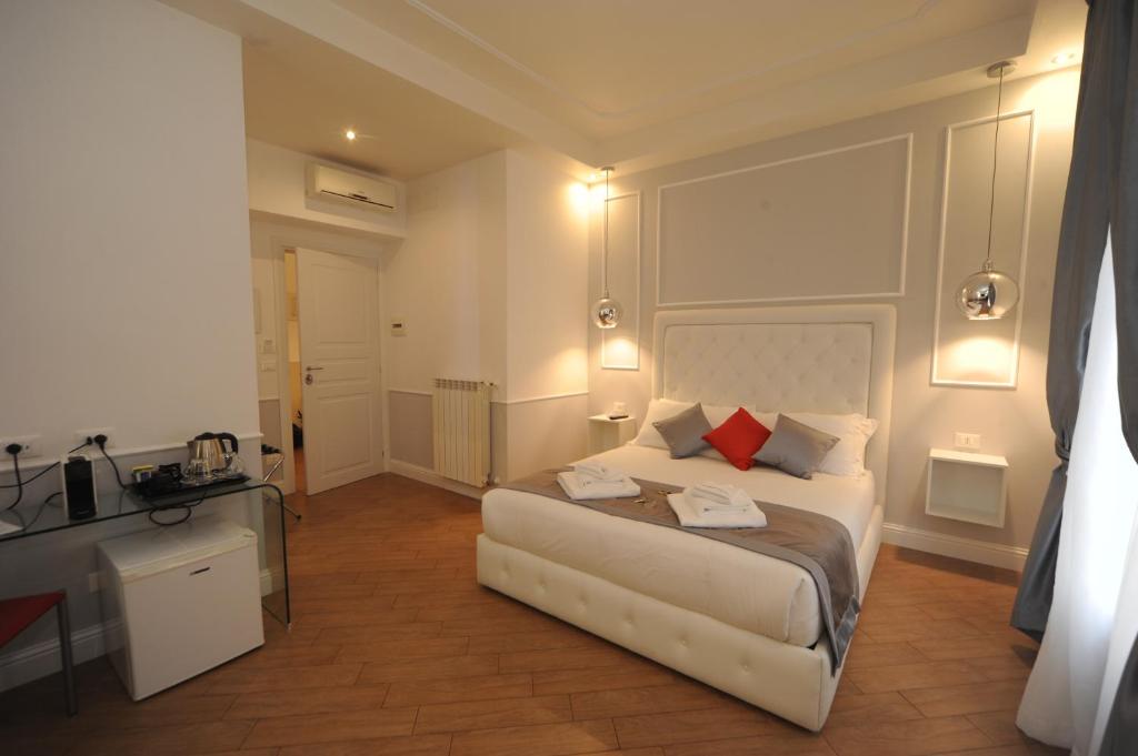 罗马My Suites Piazza di Spagna的卧室配有带红色枕头的白色床