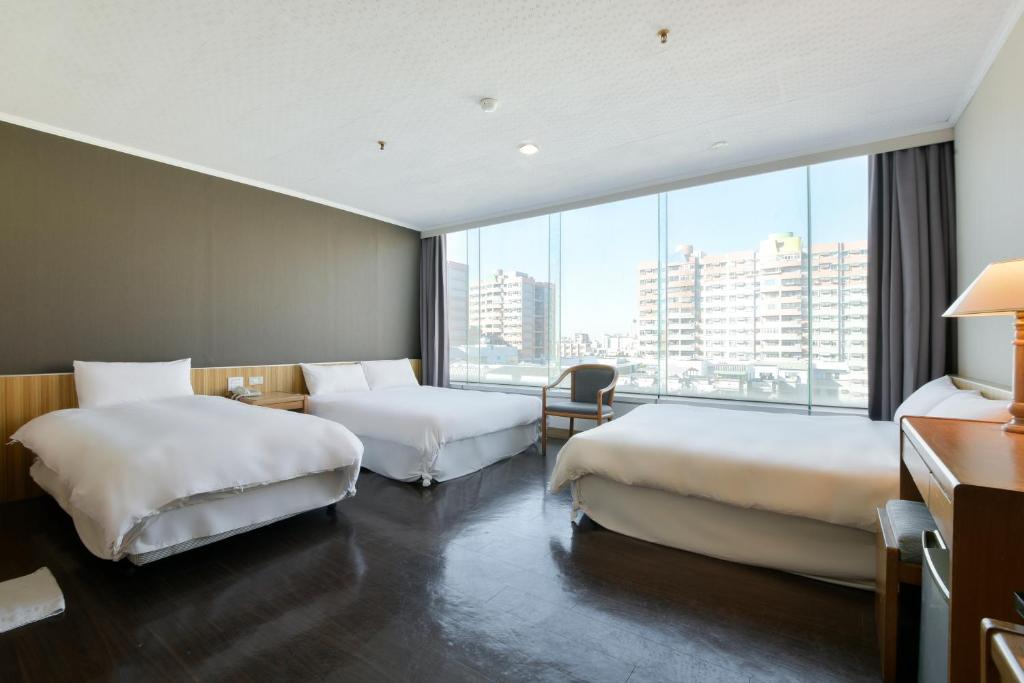 嘉义市洄嘉居行旅的酒店客房设有两张床和大窗户。