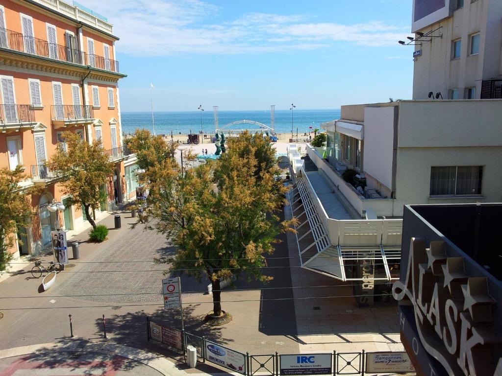 里乔内贾尔尼阿拉斯加酒店的一条城市街道,有建筑和海洋背景