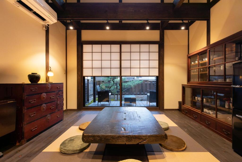 金泽Zaimoku-an的客房设有木桌和大窗户。