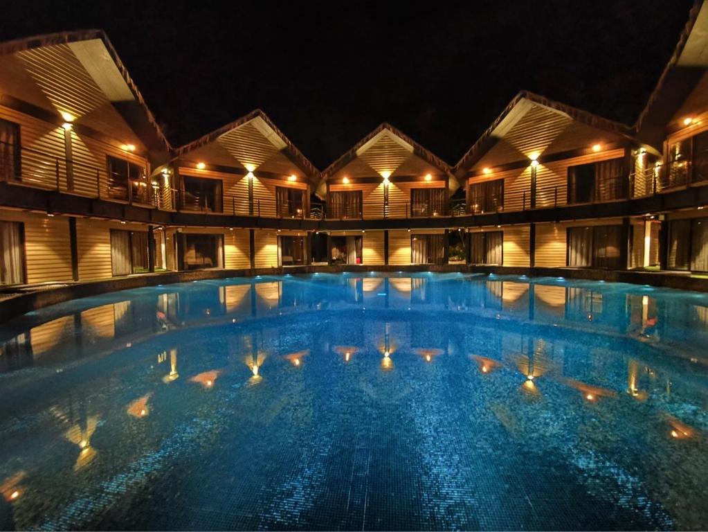 瓜埠A Rock Resort Langkawi - Coral Reefs的夜间大型游泳池,灯光照亮