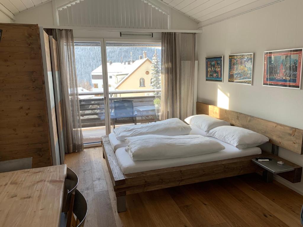 弗利姆斯Studio Top im des Alpes的一间卧室设有一张床和一个大窗户