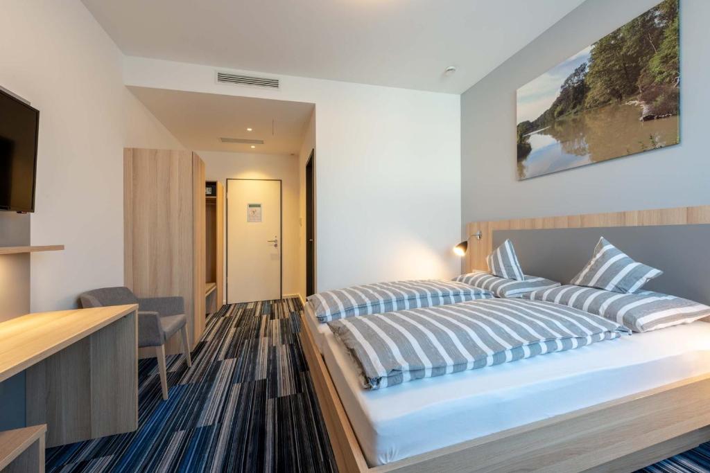 弗莱堡Hotel Lumi的一间卧室配有一张带蓝白色枕头的大床