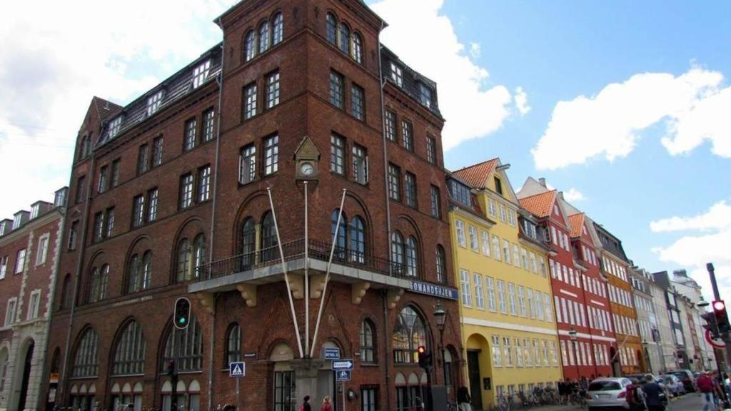 哥本哈根Hotel Bethel的街道上一座大型砖砌建筑,设有阳台