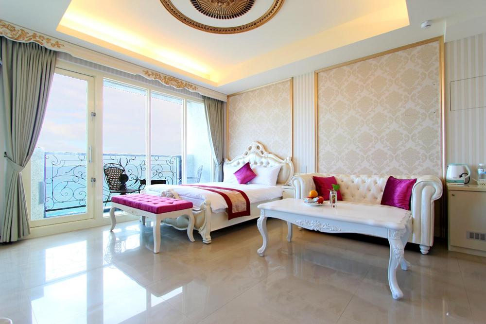 Dahan迎星会馆的一间卧室配有一张床、一张沙发和一个窗口