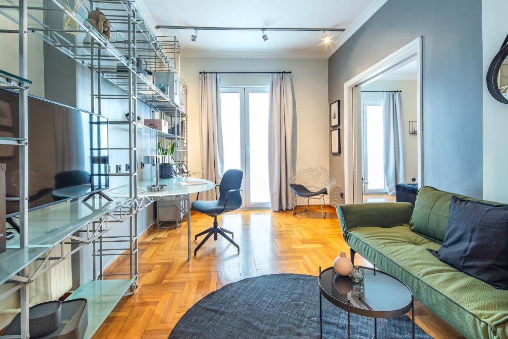 雅典Superb 1BD Apartment in the heart of Kolonaki by UPSTREET的客厅配有绿色沙发和玻璃架