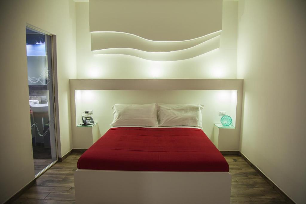 托雷阿马莱VILLA ADELAIDE SUITE & ROOM的一间卧室配有一张带红色毯子的大床