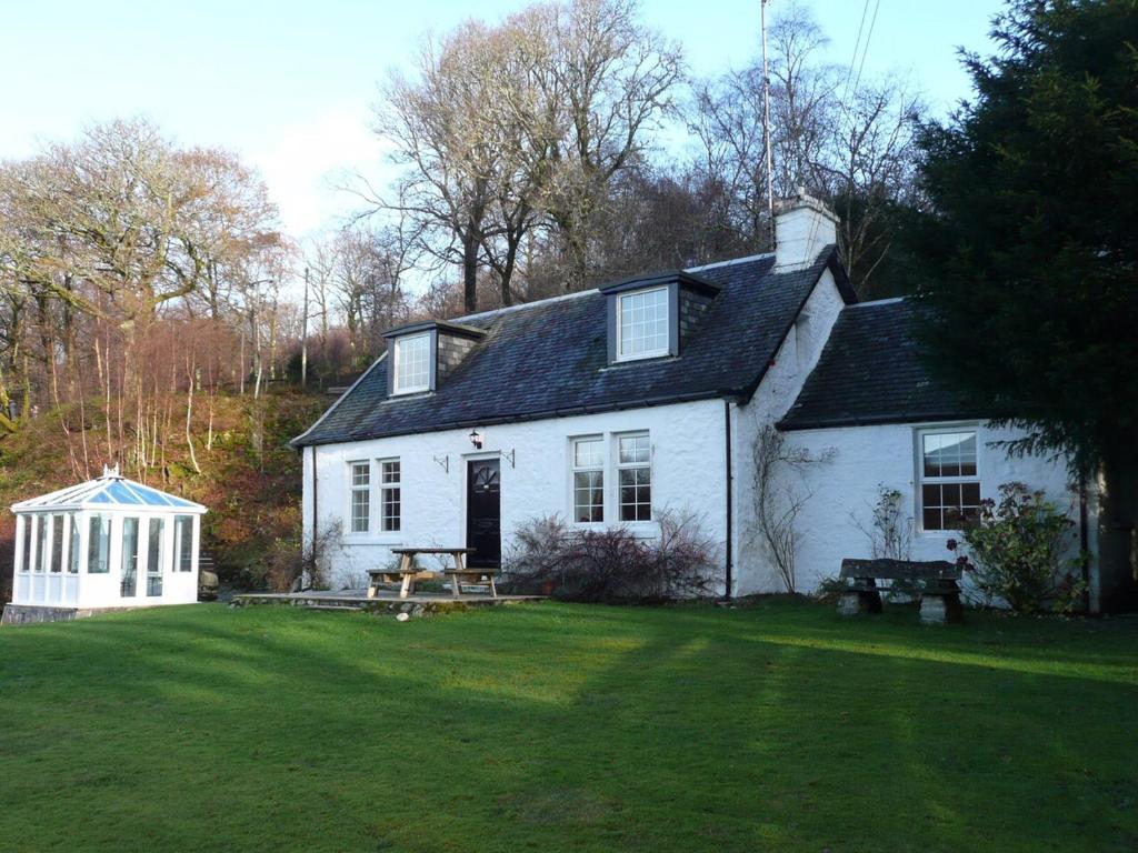 罗厄德南Dubh Loch Cottage的院子里的白色房子,带野餐桌