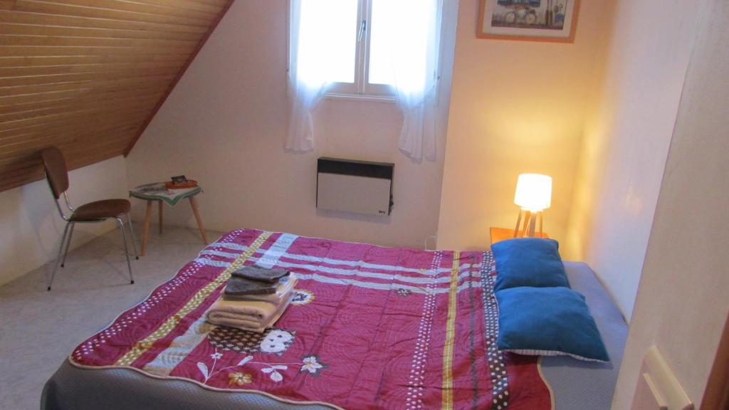 普洛戈la vallee的一间卧室配有一张带紫色毯子的床