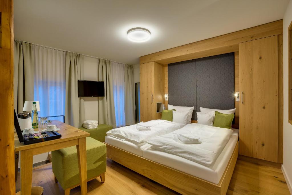 SchlettauBoutique Hotel grüner Zweig的酒店客房配有一张床铺、一张桌子和一张书桌。