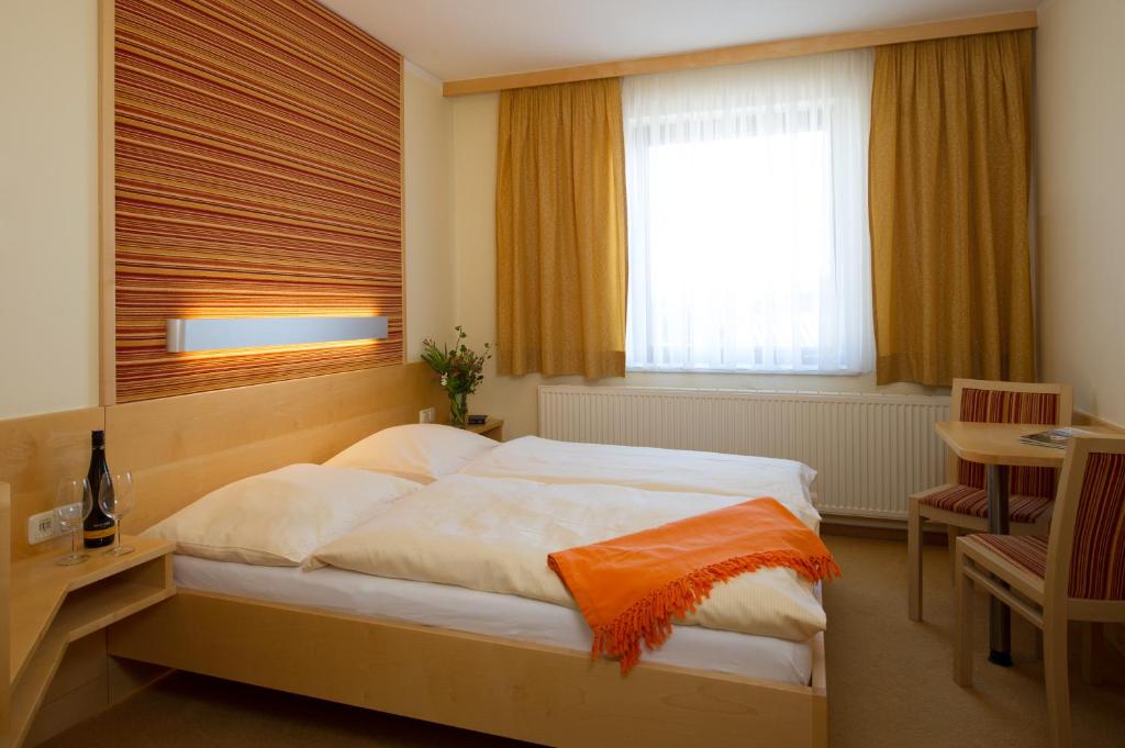 KefermarktGasthof Mader Gubo & CO KG的一间卧室配有一张床、一张书桌和一个窗户。