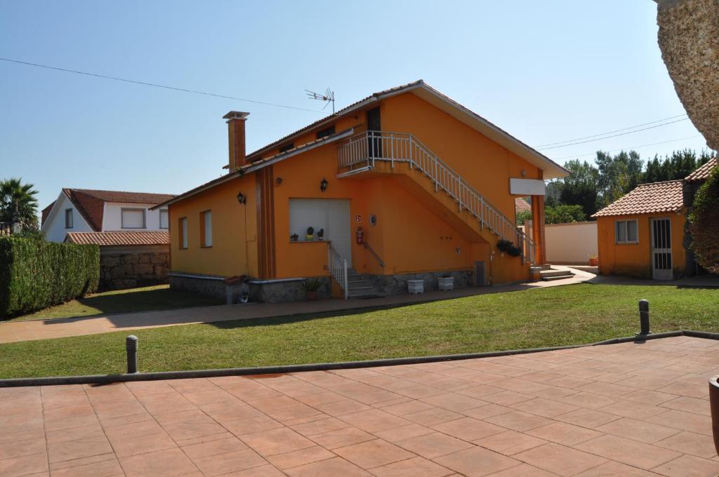 格罗韦CASA AUREA DE CACHEIRAS的一座橙色的房子,前面有楼梯