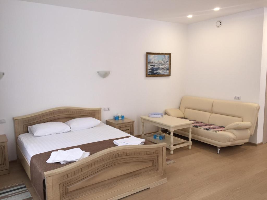 雅罗斯拉夫尔Park-Hotel Diyevo Gorodishche的一间卧室配有一张床、一把椅子和一张沙发