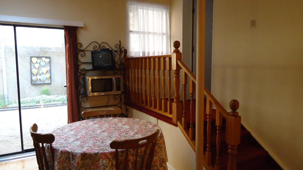 魁北克市达费林平台酒店的一间设有桌子的客房和带电视的楼梯