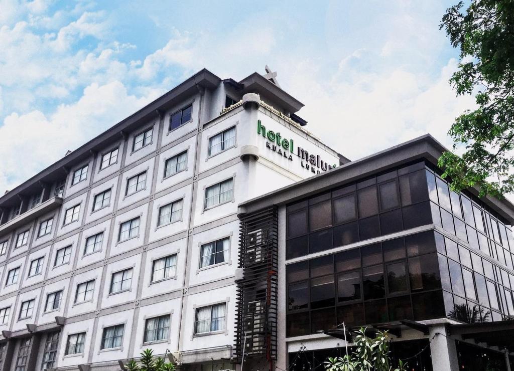 吉隆坡马鲁里酒店的一座白色的大建筑,上面有标志