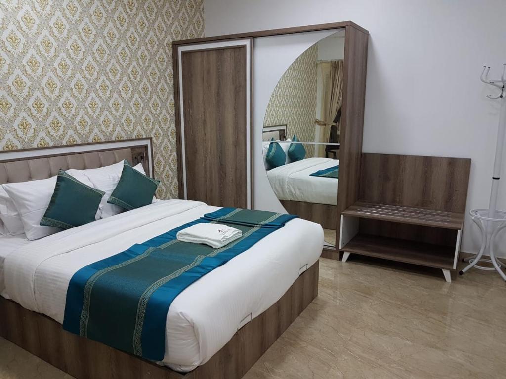 尼兹瓦Orient Apartments的一间卧室设有两张床和大镜子