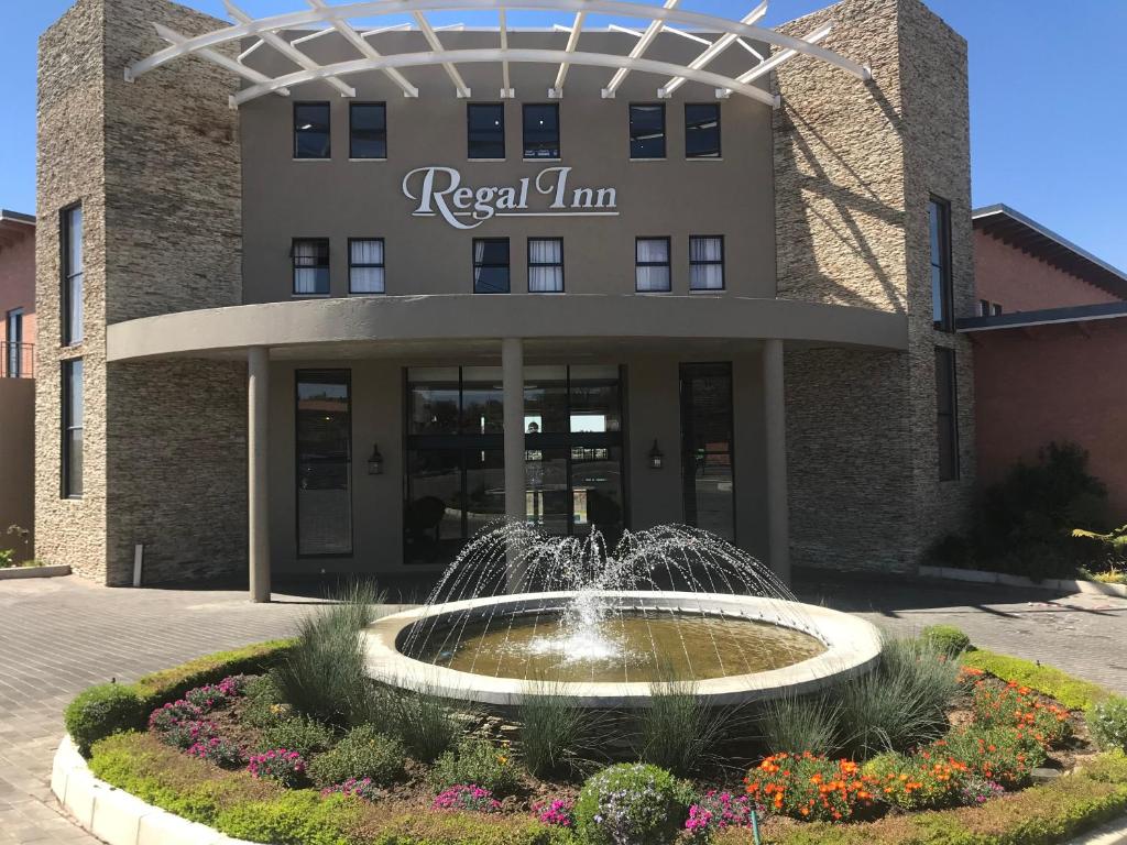 米德兰Regal Inn Hotel Midrand的建筑物前方有喷泉的建筑物