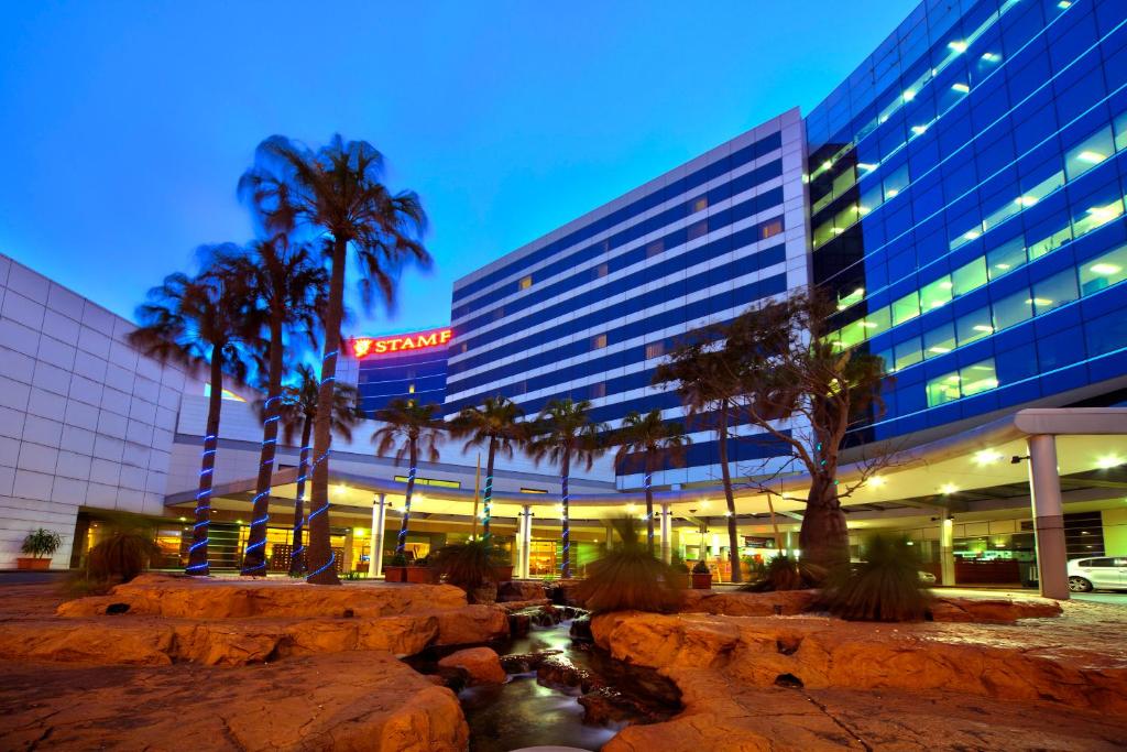 悉尼Stamford Plaza Sydney Airport Hotel & Conference Centre的一座楼前有棕榈树的酒店
