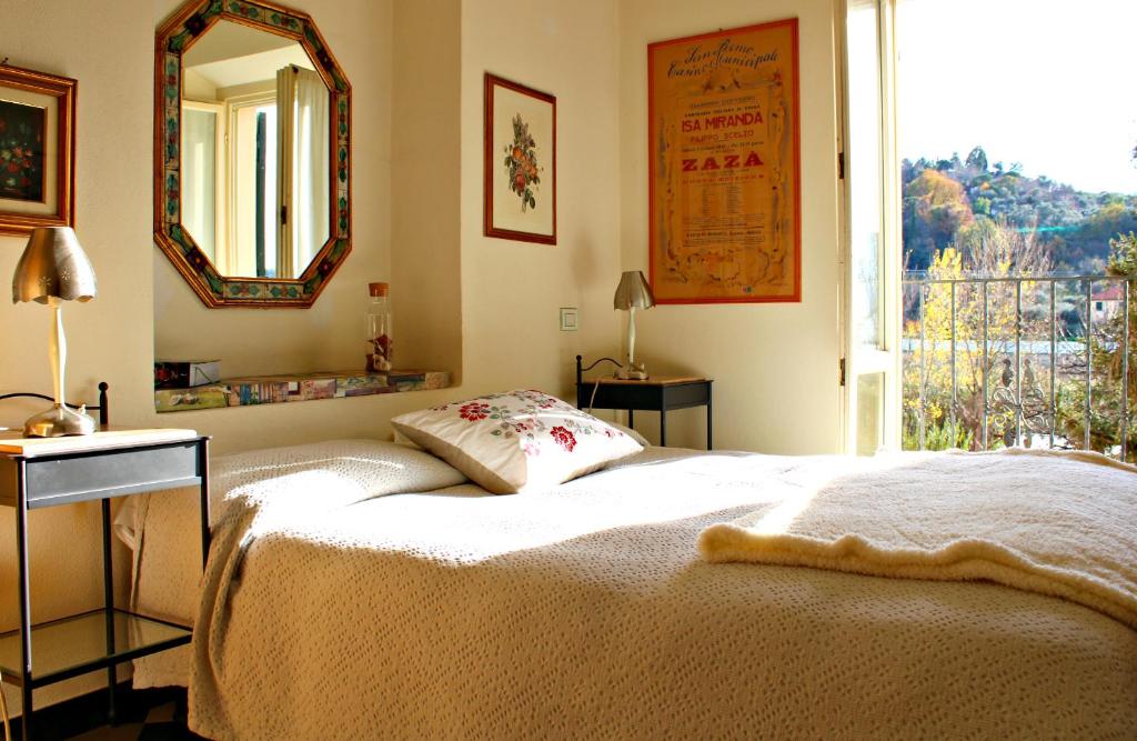卡萨尔扎利古雷I Fiori di Miranda的一间卧室配有一张床、镜子和窗户