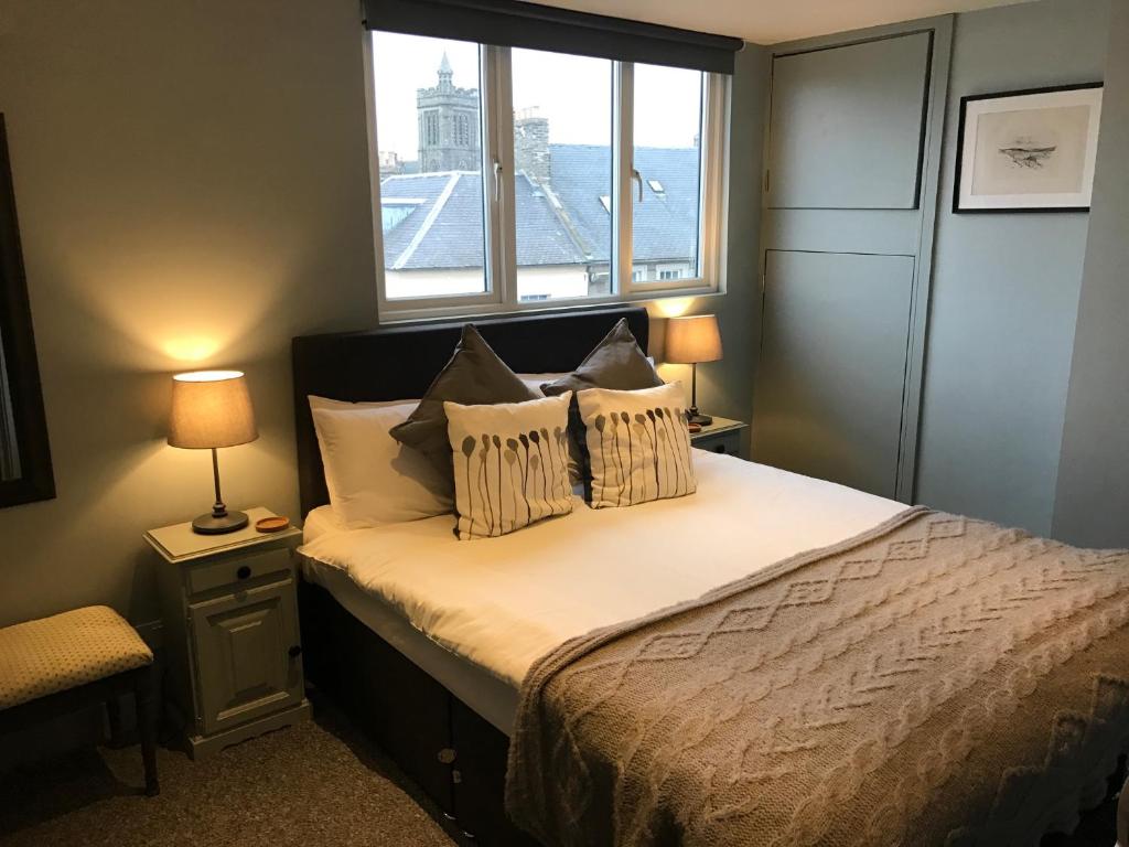 凯尔索中央旅馆的一间卧室配有带两个枕头的床和窗户