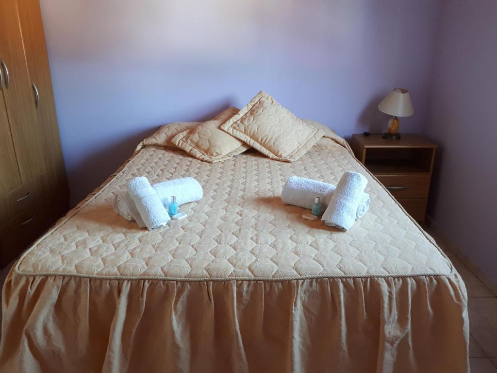 马拉圭Departamentos San Expedito的一间卧室配有一张床,上面有两条毛巾