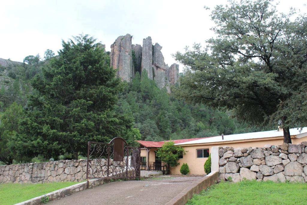 Cerocahuí帕拉伊索德尔奥索酒店的山前有石墙的建筑