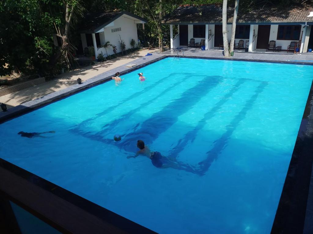 韦利格默Jagabay Resort & Surfing School的一群人在游泳池游泳