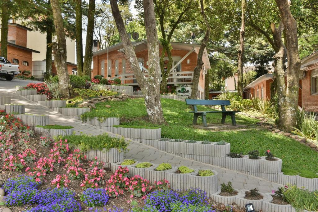 格拉玛多佩克诺博斯克酒店的种有长凳、花草树木的公园