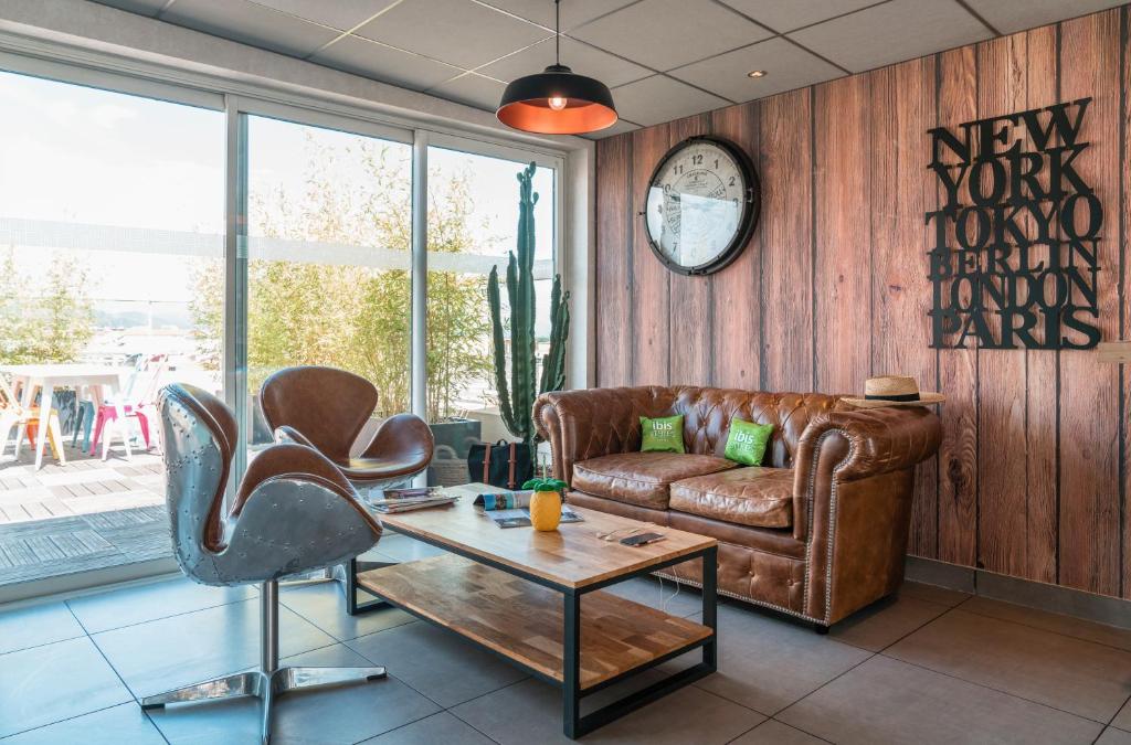耶尔Ibis Styles Hyères Rooftop & Spa的客厅配有真皮沙发和桌子