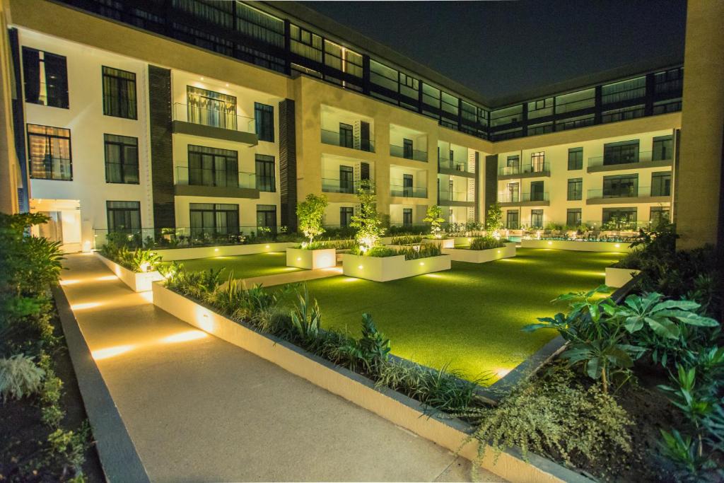 阿克拉Accra Luxury Apartments @ The Gardens的一座公寓楼,晚上有庭院