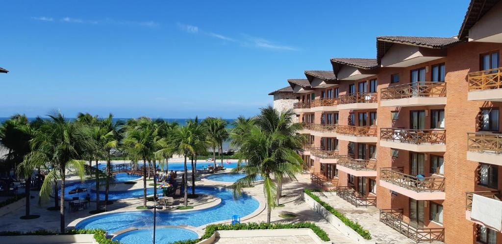 卡姆布库Manacá Apartamentos , Kariri Beach , Cumbuco的享有度假村的空中景致,设有游泳池和棕榈树