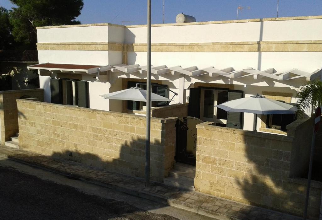 马鲁焦Casa Vacanze Roberto的建筑上带两把遮阳伞的砖墙