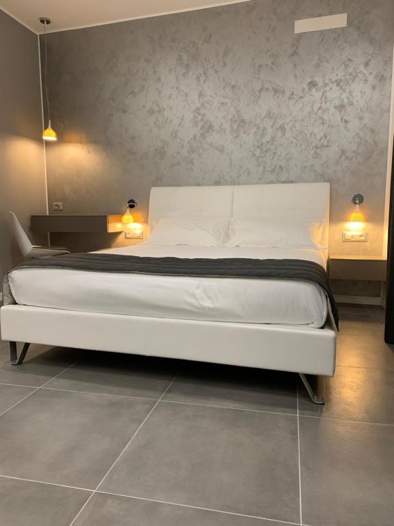 米兰ApartHotel Bossi的一间设有两盏灯的房间的一张白色床