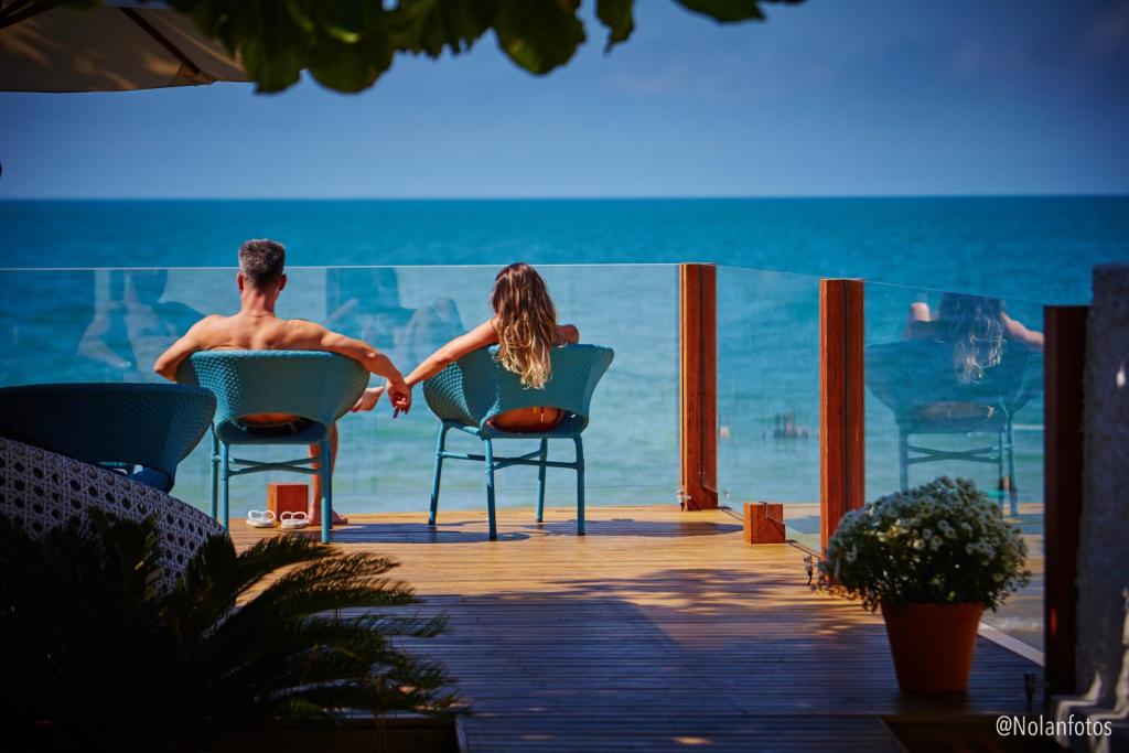 弗洛里亚诺波利斯Solar Beach Hotel的坐在沙滩椅上的男人和女人