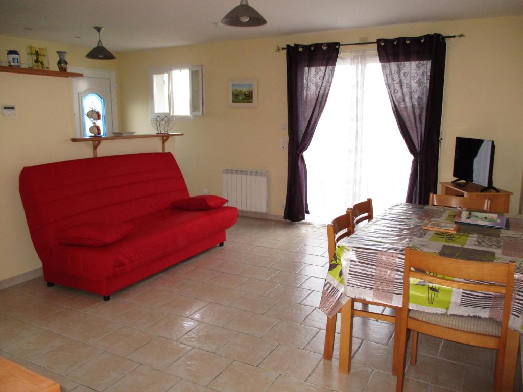 滨海苏拉克Logement Soulac sur mer的客厅配有红色的沙发和桌子
