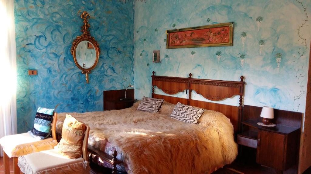 博尔戈马内罗Il Nido del Pettirosso的一间卧室设有一张床和蓝色的墙壁