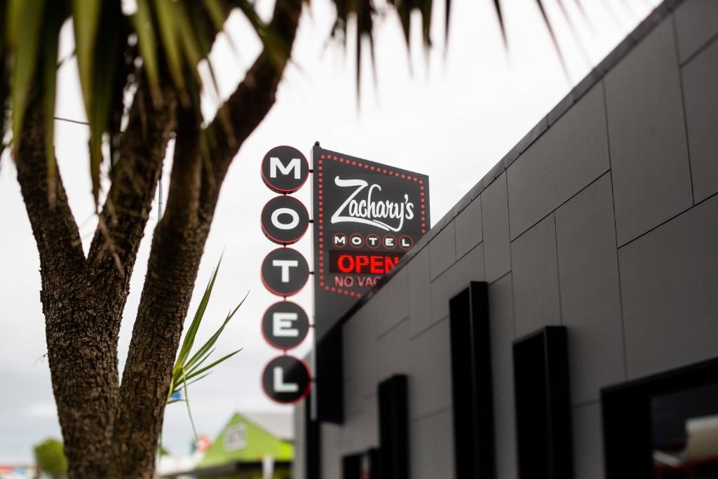 莱文Zachary's Motel的建筑物边有树的标志