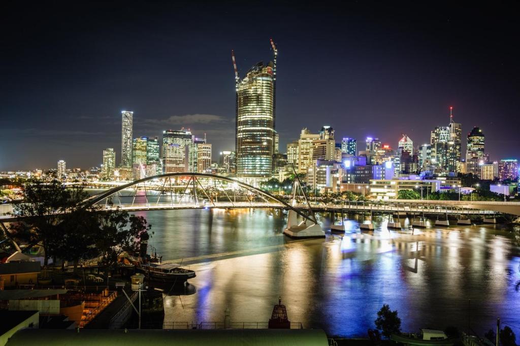 布里斯班River Plaza Apartments Brisbane的城市天际线,在晚上有一座河上的桥梁